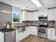 Well-lit kitchen with stainless steel appliances, granite countertops and white cabinetry at 1758 Bridlewood Ct, Gastonia, NC 28054