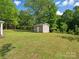 Backyard featuring a standalone shed with windows and door on a well-maintained lawn at 1758 Bridlewood Ct, Gastonia, NC 28054