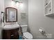 Cozy half-bathroom features a dark wood vanity with a vessel sink, tiled floors, and modern fixtures, enhancing functionality at 208 Devonport Dr # 25, Weddington, NC 28104