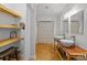Well-lit bathroom boasts double vessel sinks, wooden shelving, plank flooring, and a shower with patterned curtain at 208 Devonport Dr # 25, Weddington, NC 28104