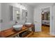 Bright bathroom features double sinks on a wood vanity with plank flooring and an open door to a bedroom at 208 Devonport Dr # 25, Weddington, NC 28104