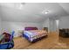 Bright bedroom featuring hardwood floors, a large bed, and a dedicated workspace at 208 Devonport Dr # 25, Weddington, NC 28104