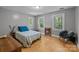 Inviting bedroom with hardwood floors, two large windows, and a comfortable seating area with a unique chair at 208 Devonport Dr # 25, Weddington, NC 28104