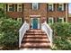 Classic brick home with a welcoming blue door and brick steps framed by lush greenery at 208 Devonport Dr # 25, Weddington, NC 28104