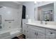 Clean bathroom featuring a bathtub and shower combination, white cabinets, and a large mirror at 21136 Cold Spring Ln, Cornelius, NC 28031