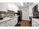 Bright kitchen with white cabinets, black appliances, and stylish backsplash at 21136 Cold Spring Ln, Cornelius, NC 28031