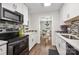 Modern kitchen with white cabinetry, tiled backsplash, and stainless steel appliances at 21136 Cold Spring Ln, Cornelius, NC 28031