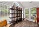 Sunroom featuring multiple windows bringing in plenty of light with hard wood floors and custom shelving at 21136 Cold Spring Ln, Cornelius, NC 28031