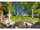 Serene backyard showcasing a paver patio with fire pit, seating area and lush lawn at 246 Mallard Head Dr, Rock Hill, SC 29732