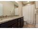 Well-lit bathroom featuring granite countertops, dual undermount sinks, tile floors, and a shower with tub at 3001 Henshaw Rd, Waxhaw, NC 28173