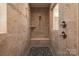 Amazing shower features beautiful tile, shower bench, mosaic tile flooring, and shower and body spray system at 3001 Henshaw Rd, Waxhaw, NC 28173