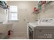 Convenient laundry room with washer and dryer, sink, a window, and shelving for storage at 3001 Henshaw Rd, Waxhaw, NC 28173