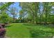 Expansive backyard featuring lush greenery, mature trees, and a well-kept lawn at 309 Catawba Ave, Davidson, NC 28036