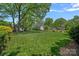Spacious, green backyard with mature trees, a fenced perimeter, and lush landscaping at 309 Catawba Ave, Davidson, NC 28036