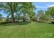 Large backyard with manicured lawn, mature trees, and privacy fencing at 309 Catawba Ave, Davidson, NC 28036