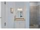 Modern bathroom featuring a granite vanity, designer wallpaper, and a frameless glass shower at 309 Catawba Ave, Davidson, NC 28036