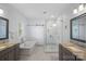 Well-lit bathroom featuring a glass-door shower and soaking tub with gray cabinets at 309 Catawba Ave, Davidson, NC 28036