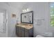 Bathroom featuring wallpaper with gray geometric pattern, a vanity with a granite countertop and framed mirror at 309 Catawba Ave, Davidson, NC 28036
