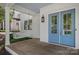 Inviting front porch with a swing, blue door, and classic architectural details at 309 Catawba Ave, Davidson, NC 28036
