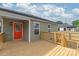 New wooden back deck featuring a bright orange door and neutral colored siding at 320 Evans Nw St, Concord, NC 28027