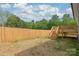 Fenced in backyard with fresh straw, wood stairs, and a new back deck at 320 Evans Nw St, Concord, NC 28027