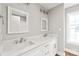Bathroom featuring double sinks, white cabinets, marble counters, and modern fixtures at 320 Evans Nw St, Concord, NC 28027