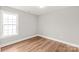 Well-lit bedroom with large window and luxury vinyl plank flooring at 320 Evans Nw St, Concord, NC 28027