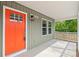 Close-up showcasing the vibrant red front door and charming covered porch with white pillars at 320 Evans Nw St, Concord, NC 28027