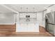 Contemporary kitchen with stainless appliances, white cabinets, and a sleek island, perfect for cooking at 320 Evans Nw St, Concord, NC 28027