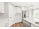 Bright kitchen with stainless steel refrigerator, modern appliances, and white cabinetry at 320 Evans Nw St, Concord, NC 28027