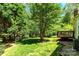 Lush backyard with shade trees and a small deck to the right at 3200 Tallia Ct, Charlotte, NC 28269