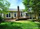 View of the house from the green and well-maintained backyard, showing the deck and brick chimney at 3200 Tallia Ct, Charlotte, NC 28269