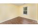 A spacious bedroom with a window, wood floors and yellow walls at 3200 Tallia Ct, Charlotte, NC 28269