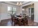 Elegant dining room with a glass-top table, six chairs and classic wainscoting and trim at 323 Cheshire Ln, Fort Mill, SC 29707