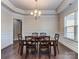 Cozy dining room featuring hardwood floors, a glass-top table with six chairs, and stylish lighting at 323 Cheshire Ln, Fort Mill, SC 29707