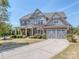 Beautiful two-story home with a well-manicured lawn, a two-car garage and stylish stone and brick facade at 323 Cheshire Ln, Fort Mill, SC 29707