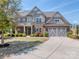 Beautiful two-story home with a well-manicured lawn, a two-car garage and stylish stone and brick facade at 323 Cheshire Ln, Fort Mill, SC 29707
