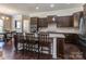 Gourmet kitchen featuring dark wood cabinetry, granite countertops, stainless steel appliances and a breakfast bar with seating at 323 Cheshire Ln, Fort Mill, SC 29707