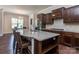 This kitchen features granite countertops, dark cabinets, a wine refrigerator, and eat in seating at 323 Cheshire Ln, Fort Mill, SC 29707