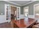 Bright home office with hardwood floors, and a wooden desk, featuring large French doors at 323 Cheshire Ln, Fort Mill, SC 29707