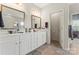 Main bathroom with double vanity sinks, white cabinets, tiled floors, and well-lit mirrors at 341 Pleasant Hill Se Dr, Concord, NC 28025