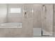 Modern bathroom featuring a soaking tub, walk-in shower, and tiled walls at 341 Pleasant Hill Se Dr, Concord, NC 28025