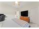 Bright bedroom boasts a ceiling fan, a dresser with a TV on top, and a view into a hallway at 341 Pleasant Hill Se Dr, Concord, NC 28025