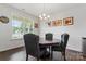 Chic dining area with dark wood table, gray upholstered chairs, and natural light from a window at 341 Pleasant Hill Se Dr, Concord, NC 28025
