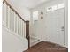 Bright foyer with white door, staircase, and wood-look floors creating an inviting entrance at 341 Pleasant Hill Se Dr, Concord, NC 28025