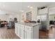 Open-concept kitchen featuring a center island with granite countertop, stainless steel fridge, and wood flooring at 341 Pleasant Hill Se Dr, Concord, NC 28025