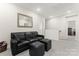 Cozy loft features neutral paint, plush carpet, and a comfortable black leather sofa, perfect for relaxation at 341 Pleasant Hill Se Dr, Concord, NC 28025