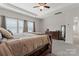 Well-lit main bedroom with tray ceiling, large windows, plush carpet, and a wooden dresser at 341 Pleasant Hill Se Dr, Concord, NC 28025