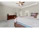 Bright main bedroom with tray ceiling, ceiling fan, plush carpet, and two wooden dressers at 341 Pleasant Hill Se Dr, Concord, NC 28025