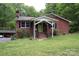 Charming brick home featuring a covered front porch, well-maintained lawn, and mature trees offering a warm, inviting curb appeal at 347 Poole Rd, Troy, NC 27371